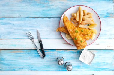 Geleneksel balık ve patates kızartması kırsal ahşap masanın üzerinde.