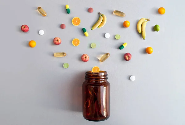 维生素丸和胶囊 以及从药罐中取出的苹果 石灰和橙子 营养概念 — 图库照片