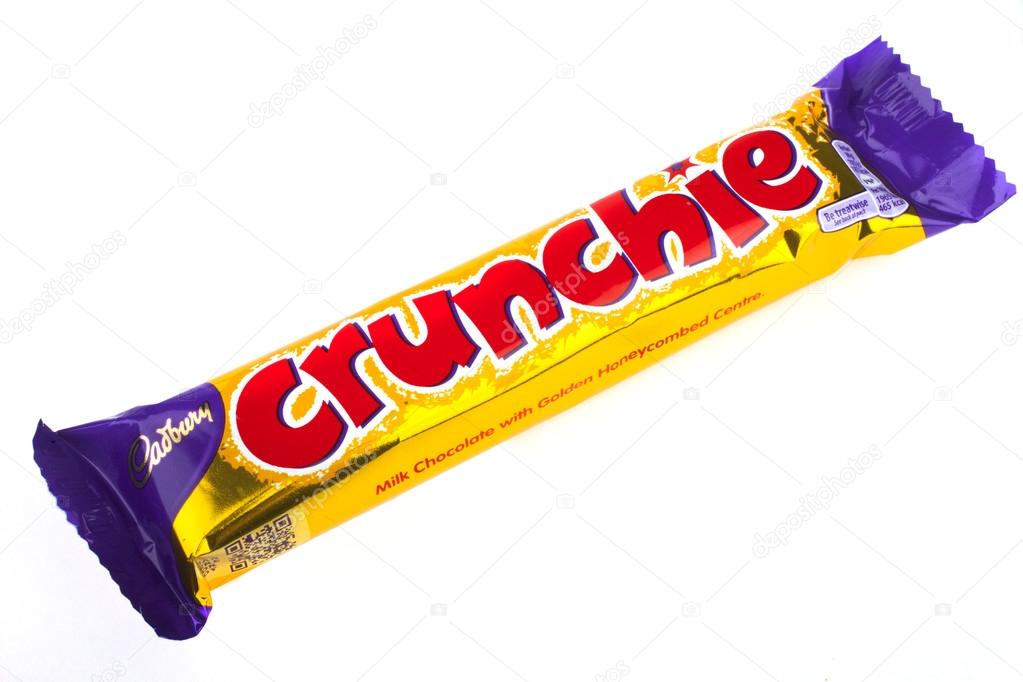LONDON, UK - JUNE 16TH 2016: An unopened Crunchie chocolate bar manufactured by Cadbury, pictured over a plain white background on 16th June 2016.