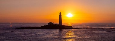Güneş doğarken Northumberland, İngiltere 'deki Whitley Körfezi yakınlarındaki güzel St. Marys Deniz Feneri' nin panoramik manzarası..
