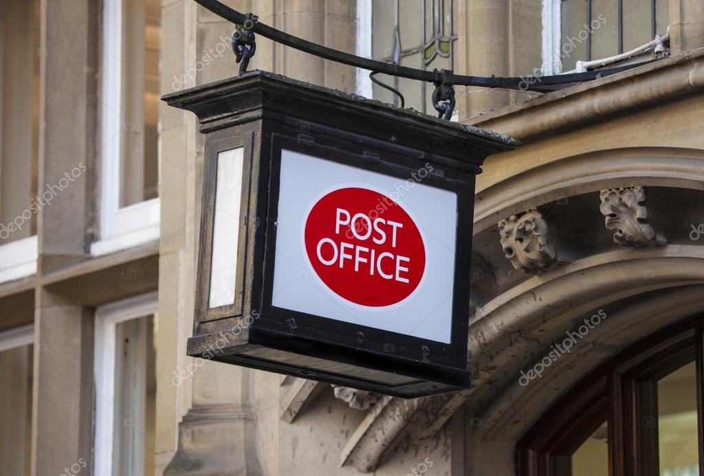 A Post Office sign hanging above a doorway.