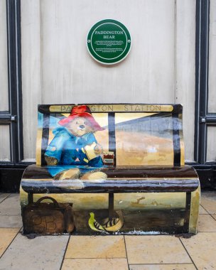 Londra, İngiltere - 24 Mart 2025: Paddington Ayısı anısına Londra, İngiltere 'deki tarihi Paddington İstasyonu' nda 1 numaralı platformda bir bank ve plaket