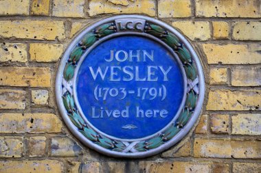 Londra, İngiltere - 3 Nisan 2025: Londra, İngiltere 'deki Wesley' s House 'un dış tarafında tarihi din adamı, ilahiyatçı ve evangelist John Wesley anısına yapılmış mavi bir plaket.