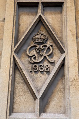 Glastonbury, İngiltere - 1 Mayıs 2024: Glastonbury, Somerset 'teki bir binanın dış cephesinde Kral VI. George' un armasına yakın çekim.