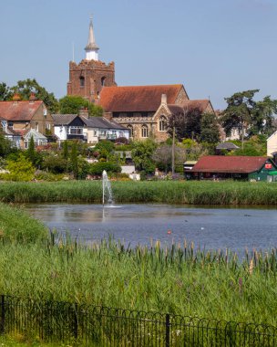 Essex, İngiltere - 27 Haziran 2024: İngiltere 'nin Essex kentindeki güzel Maldon kasabası Promenade Park' ta gölün karşısına bakın. St. Marys Kilisesi uzaktan görülebilir..