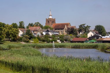 Essex, İngiltere - 27 Haziran 2024: İngiltere 'nin Essex kentindeki güzel Maldon kasabası Promenade Park' ta gölün karşısına bakın. St. Marys Kilisesi uzaktan görülebilir..