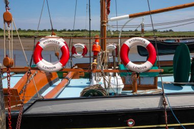 Essex, İngiltere - 27 Haziran 2024: İngiltere 'nin Essex kentindeki Hythe rıhtımına demirlenmiş Hidrojen yelkenli mavnasında Lifebuoy halkaları.