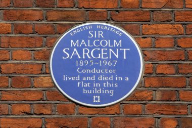 Londra, İngiltere - 29 Temmuz 2024: Londra, İngiltere 'de Albert Hall Mansions' ın dış tarafında, ünlü şef Sör Malcolm Sargent 'ın yaşadığı ve öldüğü yeri gösteren mavi bir plaket.