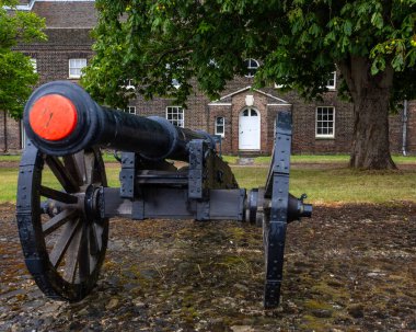 Essex, İngiltere - 7 Temmuz 2024: Arka planda Subay Kışlası, Essex, İngiltere 'deki tarihi Tilbury Kalesi' nde bir top görüntüsü.