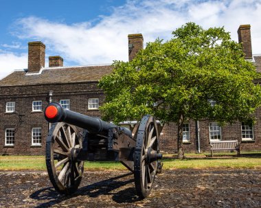 Essex, İngiltere - 7 Temmuz 2024: Arka planda Subay Kışlası, Essex, İngiltere 'deki tarihi Tilbury Kalesi' nde bir top görüntüsü.