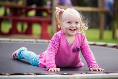 Dışarıda oynayan küçük sarışın bir kızın görüntüsünü kapat.