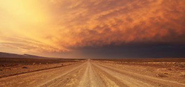Güney Afrika 'nın Büyük Karoo' sunda tek bir toprak yol üzerinde büyük bir gök gürültüsü fırtınası.