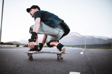 Açık bir yolda kaykaycı serbest stil numaraları yapıyor.
