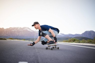 Açık bir yolda kaykaycı serbest stil numaraları yapıyor.