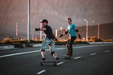 Açık bir yolda kaykaycı serbest stil numaraları yapıyor.