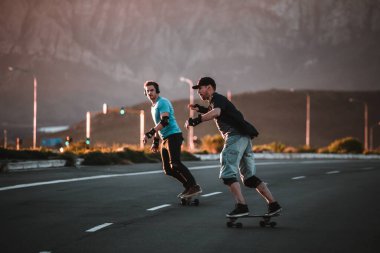 Açık bir yolda kaykaycı serbest stil numaraları yapıyor.