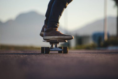 Açık bir yolda kaykaycı serbest stil numaraları yapıyor.