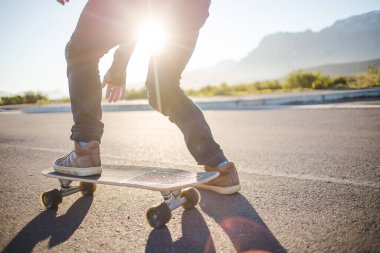 Açık bir yolda kaykaycı serbest stil numaraları yapıyor.