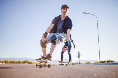 Açık bir yolda kaykaycı serbest stil numaraları yapıyor.