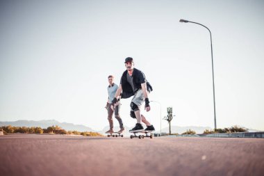 Açık bir yolda kaykaycı serbest stil numaraları yapıyor.