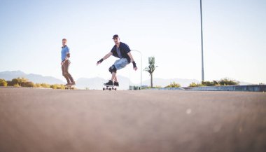 Açık bir yolda kaykaycı serbest stil numaraları yapıyor.