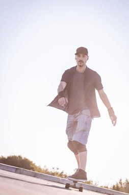 Açık bir yolda kaykaycı serbest stil numaraları yapıyor.