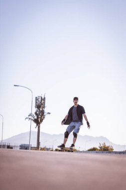 Açık bir yolda kaykaycı serbest stil numaraları yapıyor.