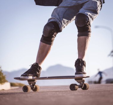 Açık bir yolda kaykaycı serbest stil numaraları yapıyor.