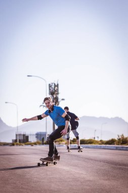 Açık bir yolda kaykaycı serbest stil numaraları yapıyor.