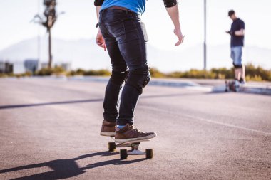 Açık bir yolda kaykaycı serbest stil numaraları yapıyor.