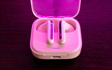 Şarj kutusunun yanında pembe kablosuz kulaklık. Kablosuz kulaklıklar nasıl çalışıyor