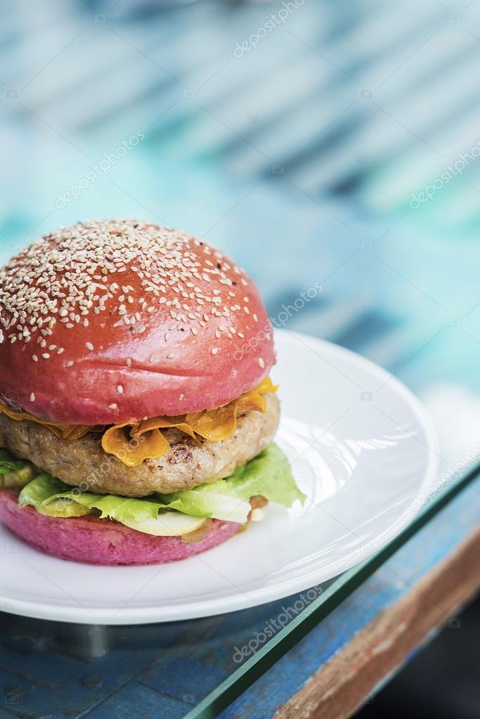 Modern gourmet chicken burger in beetroot bun Stock Photo by ...