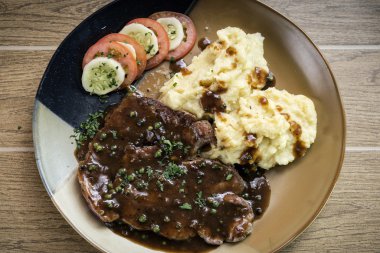 sığır eti biftek yemek patates püresi ve et suyu sosu ile