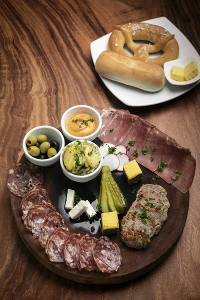 木のテーブルの上で肉やパンとドイツの冷たいカットタパススナックプレート背景 — ストック写真