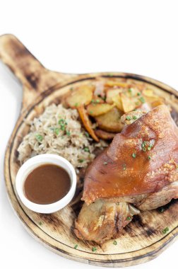 SCHWEINSHAXE Geleneksel Alman domuz budu lahana turşulu ve beyaz arka planda patates yemeği
