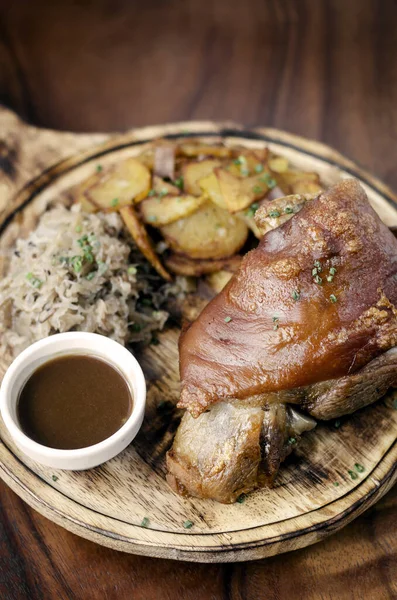 什锦沙夏传统的德国猪肉指节 有德国泡菜和土豆面包 背景为乡村木料 — 图库照片