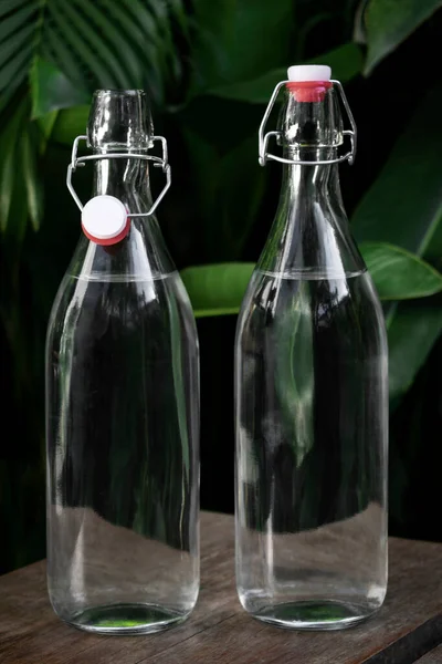 Klares Weißes Glas Flip Top Wasserflasche Freien Auf Dem Gartentisch — Stockfoto