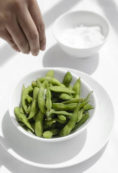 Mão Salgar Feijão Edamame Lanche Tigela Mesa Restaurante Branco — Fotografia de Stock