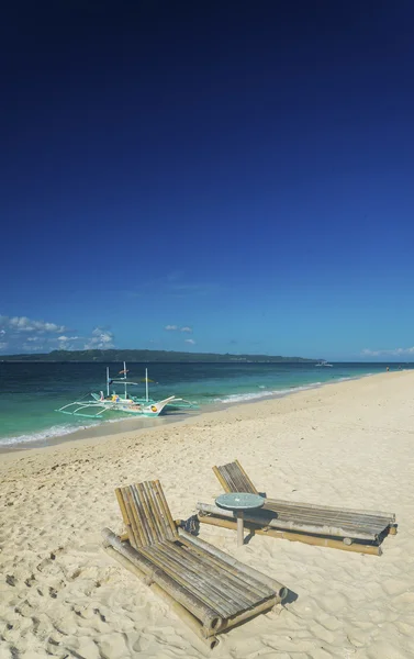 Sedie a sdraio e barca tradizionale sulla spiaggia di puka in boracay phil — Foto Stock