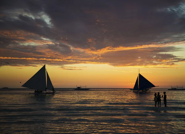 Sunset and tourist sailing boats on tropical white beach in bora — Stock Photo, Image