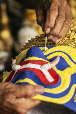 Kamboçya 'da ressam Lakhon Khol' un geleneksel dans maskesini çizerken.