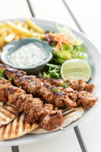 Yunanistan 'da Mykonos restoranındaki beyaz masada tavuk şişi jiroskopu tabağı.