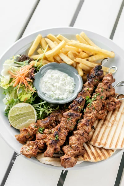 Yunanistan 'da Mykonos restoranındaki beyaz masada tavuk şişi jiroskopu tabağı.