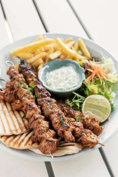 Yunanistan 'da Mykonos restoranındaki beyaz masada tavuk şişi jiroskopu tabağı.