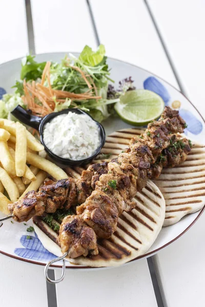 Yunanistan 'da Mykonos restoranındaki beyaz masada tavuk şişi jiroskopu tabağı.