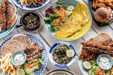 Mykonos Greece 'deki restoran masasında bir sürü farklı karışık Akdeniz yemekleri var.