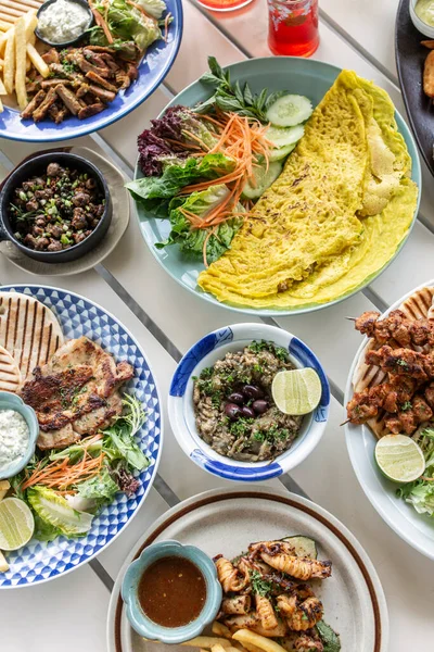 Mykonos Greece 'deki restoran masasında bir sürü farklı karışık Akdeniz yemekleri var.