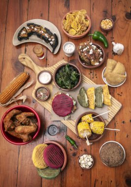 Geleneksel Kolombiya ve Venezuela yemekleri ahşap restoran masasına yayılmış.