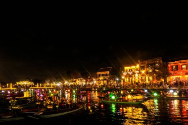 HOI AN, VİETNAM - 8 Şubat 2026: Vietnam 'da geceleri turist feneri nehir tekneleri ile eski bir kasaba nehir manzaralı hoi
