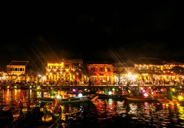 HOI AN, VİETNAM - 8 Şubat 2026: Vietnam 'da geceleri turist feneri nehir tekneleri ile eski bir kasaba nehir manzaralı hoi